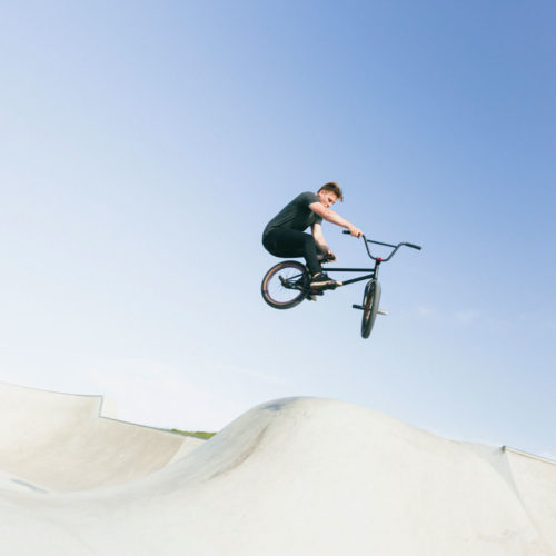 BMX rider jumping in a skatepark.