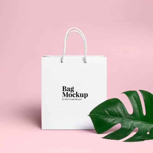 White shopping bag on pink background.